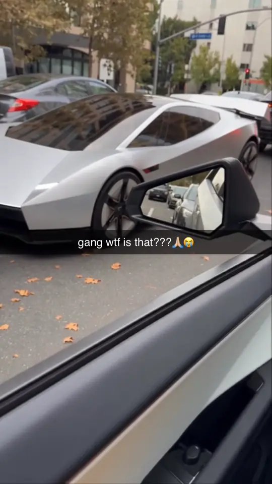 A Roadster hovers past the car window in city traffic